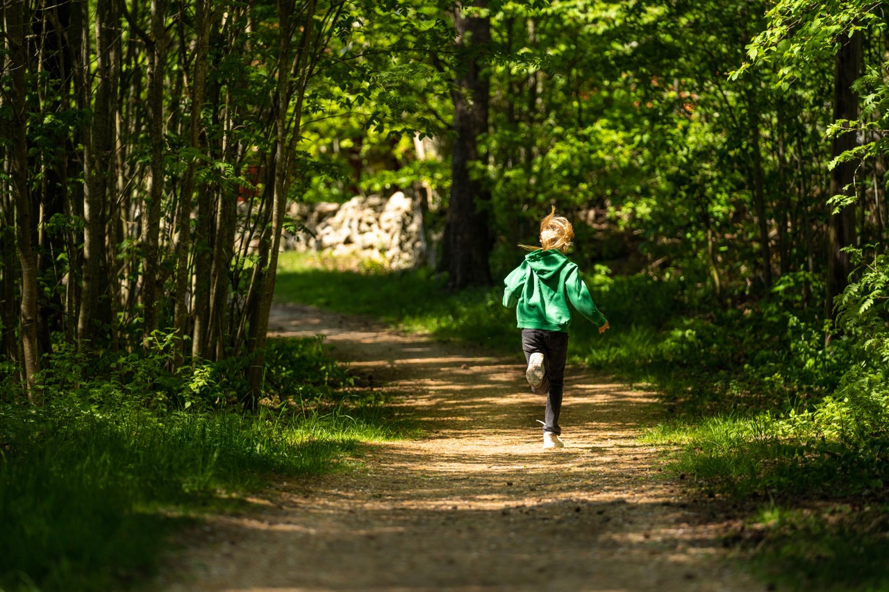 ett barn springer på en grusväg